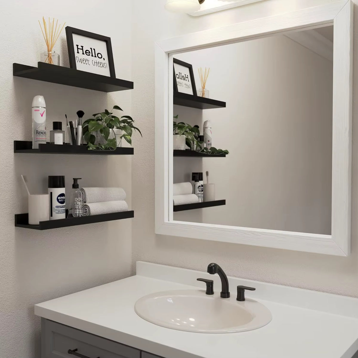 Black aluminium floating shelves in a bathroom beside the mirror